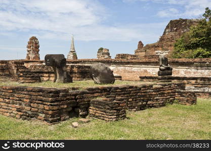 Ruins of the red brick temple of Wat Mahathat, the Temple of the Great Relic, and the remains of some headless Buddha statues, in Ayutthaya, Thailand