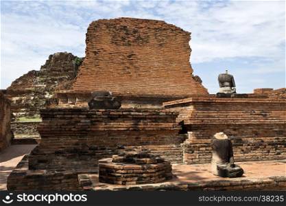 Ruins of the red brick temple of Wat Mahathat, the Temple of the Great Relic, and the remains of some headless Buddha statues, in Ayutthaya, Thailand