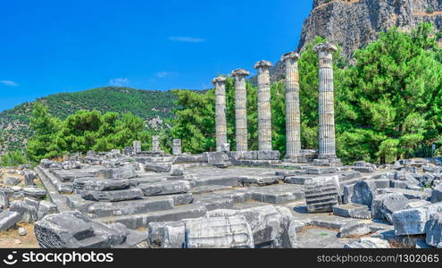 Ruins of the Temple of Athena Polias in the ancient city of Priene, Turkey, on a sunny summer day. Big panoramic shot.. The Temple of Athena Polias in the Ancient Priene, Turkey