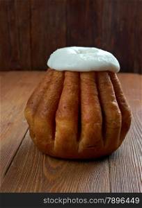 Rum baba on wooden background. cake saturated in hard liquor, usually rum, and sometimes filled with whipped cream or pastry cream.