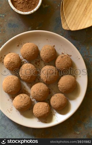 Rum balls covered with cocoa powder, photographed overhead on slate with natural light (Selective Focus, Focus on the top of the balls)