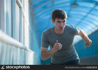 Runner athlete running on road in city. Man fitness sunrise jogging workout wellness concept.