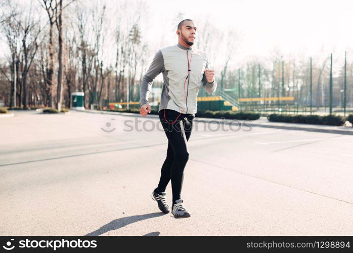 Runner in motion, speed running, healthy lifestyle. Athlete on morning fitness workout. Jogger in sportswear on training outdoor. Runner in motion, speed running, healthy lifestyle