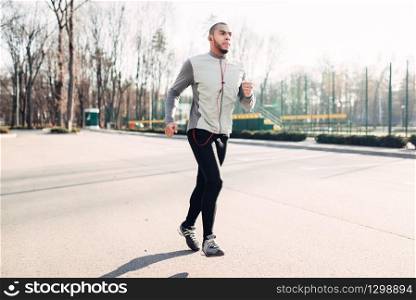 Runner in motion, speed running, healthy lifestyle. Athlete on morning fitness workout. Jogger in sportswear on training outdoor. Runner in motion, speed running, healthy lifestyle
