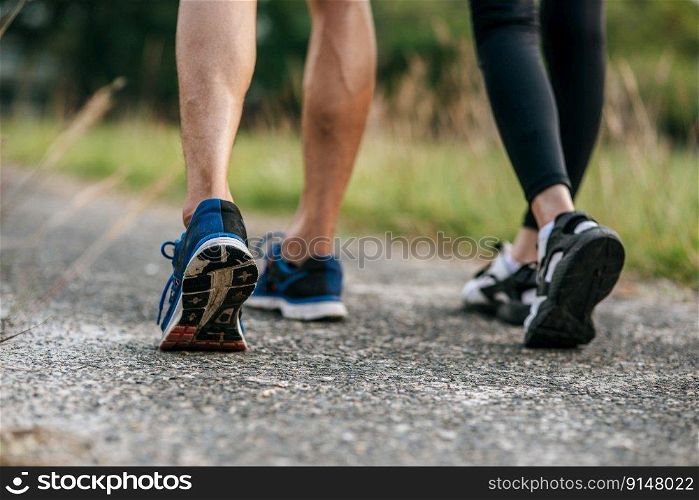 Runner woman and man feet running on road closeup on shoe. Sports healthy lifestyle concept.