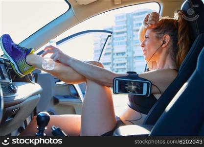 Runner woman relaxing after workout sitting inside a car