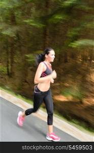 Runner - woman running outdoors training for marathon run motion blur