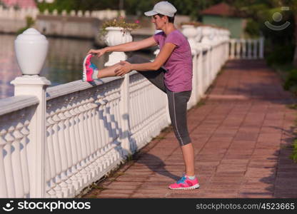 runner woman warming up and stretching before morning jogging