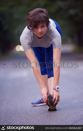 runner woman warming up and stretching before morning jogging