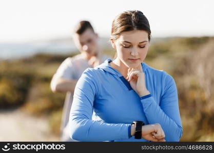 Runner woman with heart rate monitor running on beach. Young runner woman with heart rate monitor running on beach