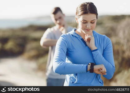 Runner woman with heart rate monitor running on beach. Young runner woman with heart rate monitor running on beach