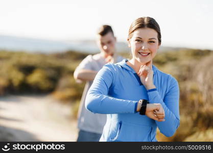 Runner woman with heart rate monitor running on beach. Young runner woman with heart rate monitor running on beach