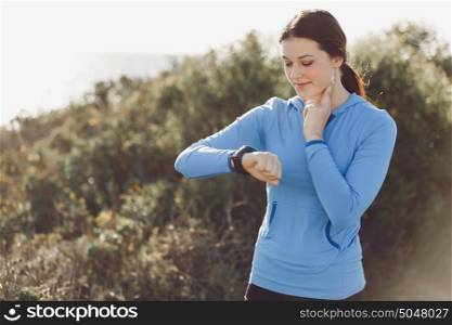 Runner woman with heart rate monitor running on beach. Young runner woman with heart rate monitor running on beach