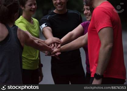 runners giving high five to each other. Group of healthy runners giving high five to each other while celebrating success after a training session.