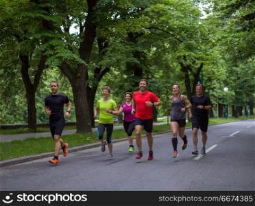 runners team on morning training. group of healthy people jogging in city park, runners team on morning training