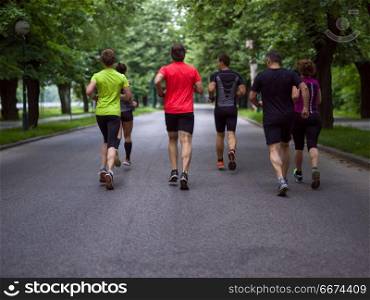 runners team on morning training. group of healthy people jogging in city park, runners team on morning training
