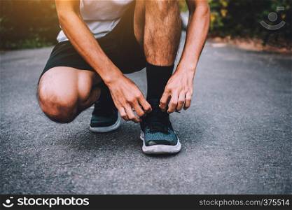 Runners tied in shoes,Man run on the street be running for exercise,Run sports background and closeup at running shoe