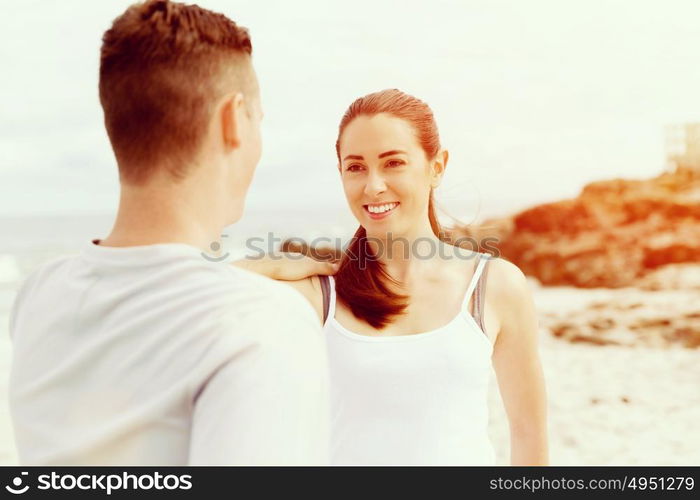 Runners. Young couple exercising and stertching on beach. Runners. Young couple doing sport on beach together