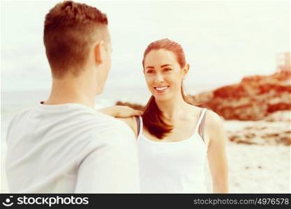 Runners. Young couple exercising and stertching on beach. Runners. Young couple doing sport on beach together