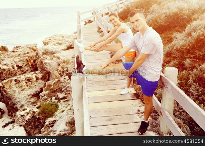 Runners. Young couple exercising on beach. Runners. Young couple doing sport on beach together