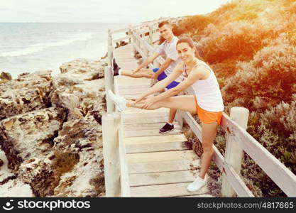 Runners. Young couple exercising on beach. Runners. Young couple doing sport on beach together