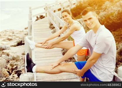 Runners. Young couple exercising on beach. Runners. Young couple doing sport on beach together