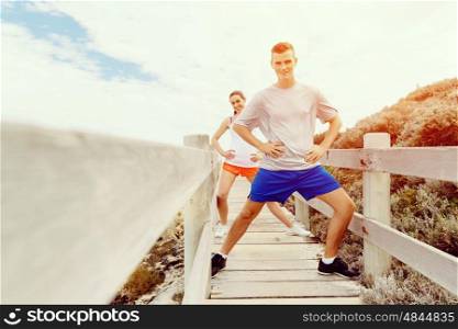 Runners. Young couple exercising on beach. Runners. Young couple doing sport on beach together