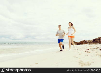 Runners. Young couple running on beach. Runners. Young couple running on beach together