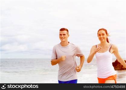Runners. Young couple running on beach. Runners. Young couple running on beach together