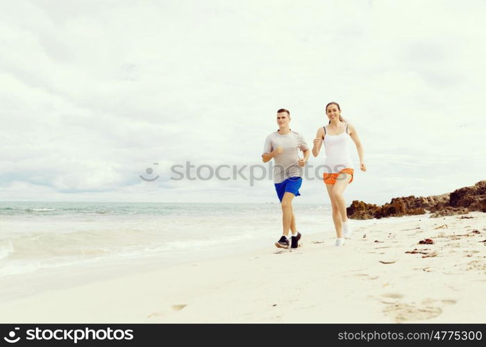 Runners. Young couple running on beach. Runners. Young couple running on beach together