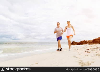 Runners. Young couple running on beach. Runners. Young couple running on beach together