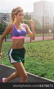 running at outdoor. A young beauty athletic woman in sportswear running at outdoor.