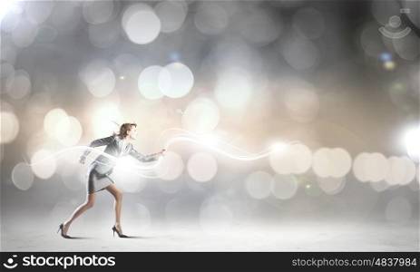 Running businesswoman. Young businesswoman in suit running against bokeh background