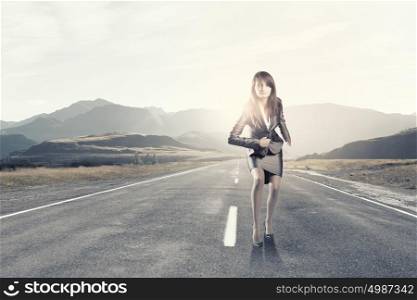 Running businesswoman. Young businesswoman in suit running on road