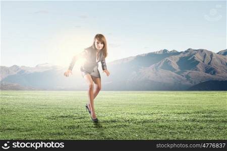 Running businesswoman. Young businesswoman in suit running on stadium track