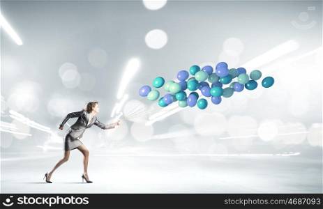 Running businesswoman. Young businesswoman running with bunch of colorful balloons
