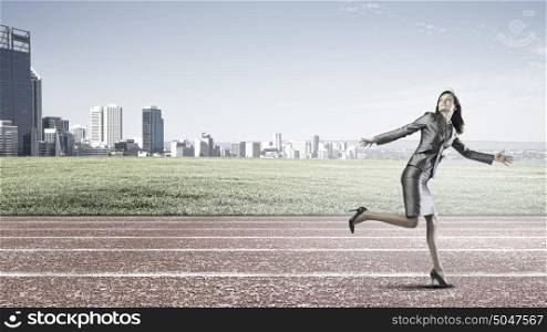 Running in a hurry!. Young businesswoman in start position ready to run