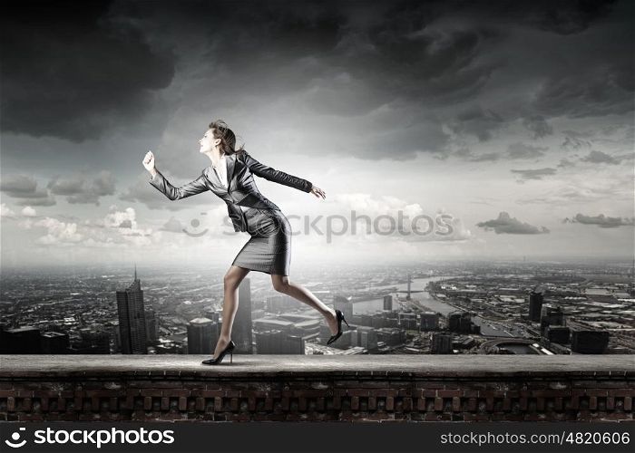 Running in a hurry. Young pretty businesswoman in suit running away