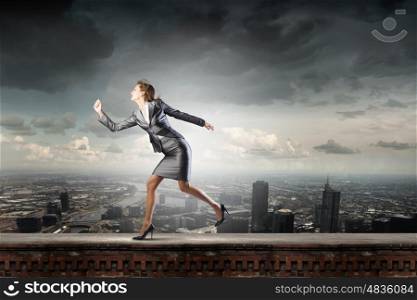 Running in a hurry. Young pretty businesswoman in suit running away