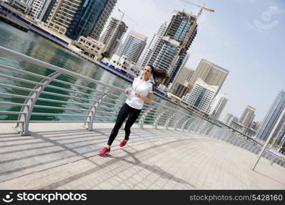 Running in city park. Woman runner outside jogging at morning with Dubai urban scene in background