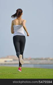 Running in city park. Woman runner outside jogging at morning with Dubai urban scene in background