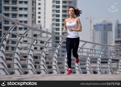 Running in city park. Woman runner outside jogging at morning with Dubai urban scene in background