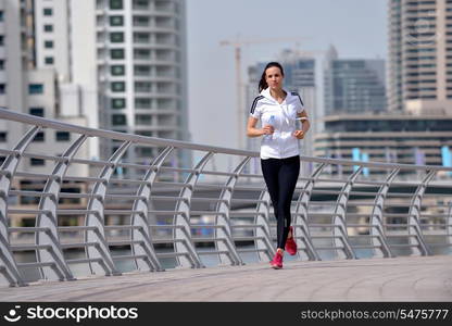 Running in city park. Woman runner outside jogging at morning with Dubai urban scene in background