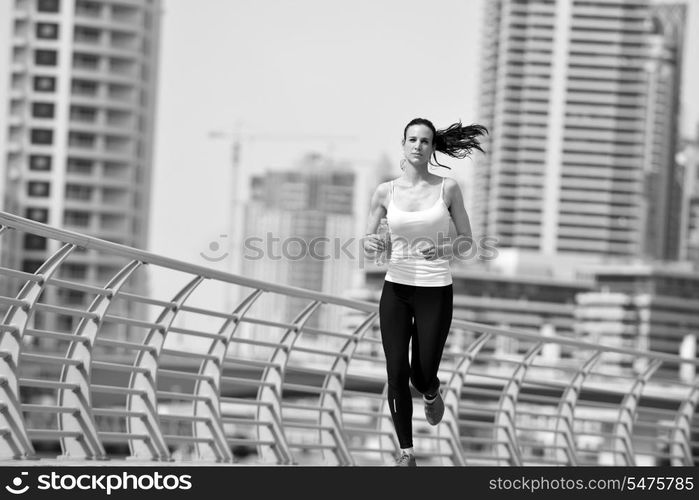 Running in city park. Woman runner outside jogging at morning with Dubai urban scene in background