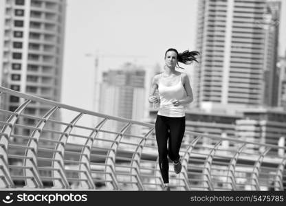 Running in city park. Woman runner outside jogging at morning with Dubai urban scene in background