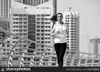 Running in city park. Woman runner outside jogging at morning with Dubai urban scene in background