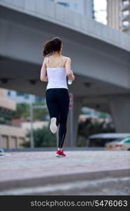 Running in city park. Woman runner outside jogging at morning with Dubai urban scene in background