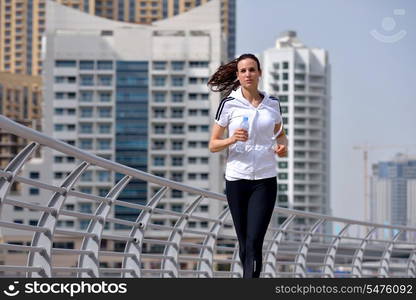 Running in city park. Woman runner outside jogging at morning with Dubai urban scene in background