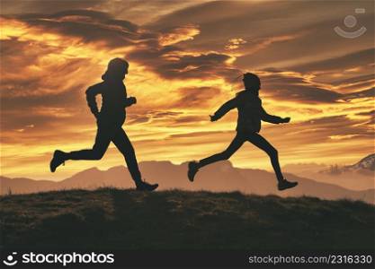 Running in nature at sunset. A mother with her daughter together