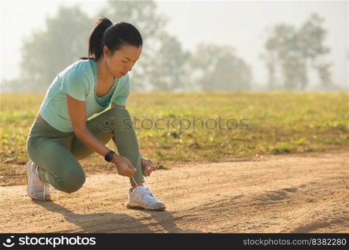 running shoes runner woman tying laces for autumn run in forest park. runner trying running shoes getting ready for run. Jogging girl exercise motivation health and fitness.